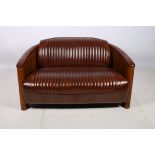 A VERY FINE HIDE UPHOLSTERED AND CHERRYWOOD AVIATION TWO SEATER SETTEE with hide upholstered