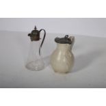 A PLATED MOUNTED CLARET JUG with scroll handle together with an art nouveau pewter lidded jug with