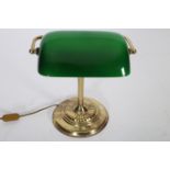 A BRASS GREEN GLASS AND OPALINE GLASS DESK TABLE LAMP with swivel shade above a reeded column on