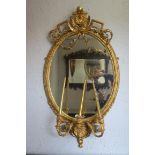 A 19TH CENTURY GILTWOOD AND GESSO GIRANDOLE MIRROR the oval plate within a strap work and bead work