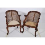 A PAIR OF HARDWOOD AND BERGERE TUB SHAPED CHAIRS the curved top rail with scroll arms on cabriole