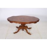 A CONTINENTAL WALNUT CROSS BANDED COFFEE TABLE of serpentine outline the shaped top above a