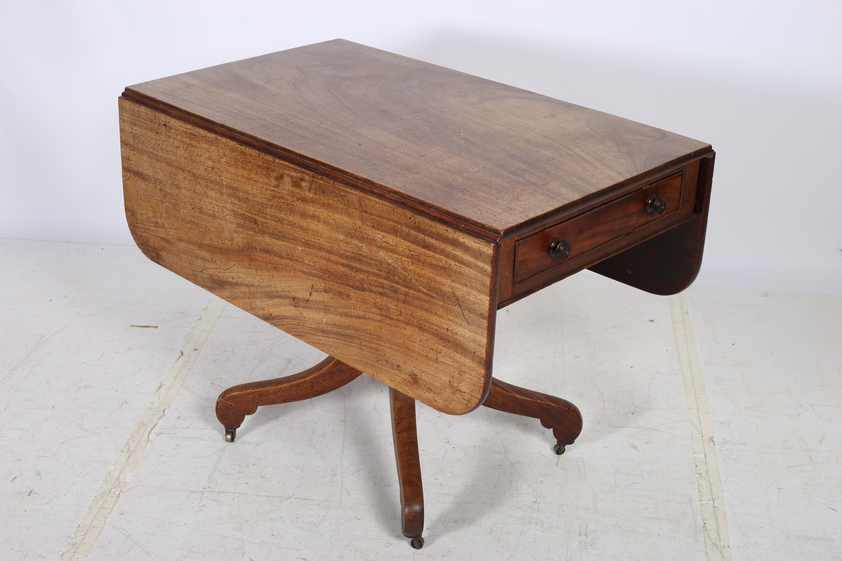 A GEORGIAN MAHOGANY DROP LEAF TABLE the rectangular hinged top with frieze drawer above a baluster
