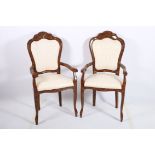 A PAIR OF CONTINENTAL SIMULATED WALNUT AND UPHOLSTERED ELBOW CHAIRS each with a shell shaped