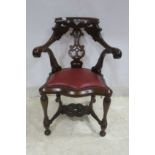 A MAHOGANY ELBOW CHAIR with pierced top rail above a vase shaped splat with scroll arms and