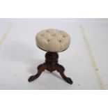 A 19TH CENTURY CARVED MAHOGANY AND UPHOLSTERED STOOL the circular upholstered seat above a baluster