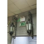 A PAIR OF WROUGHT IRON WALL MOUNTED LANTERNS each of octagonal form with frosted glazed panels with