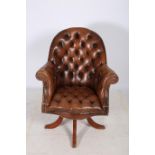 A HIDE UPHOLSTERED AND BUTTON BACK SWIVEL LIBRARY CHAIR the arched back with scroll over arms on