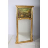 A CONTINENTAL GILT FRAMED TRUMEAU MIRROR the rectangular plate headed with a painted panel within a