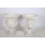 A PAIR OF COMPOSITION STONE URNS each of semi lobed campana form moulded in relief with foliate