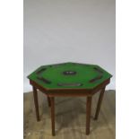 A MAHOGANY CARD TABLE of octagonal outline the shaped top with baize lining and counter wells on