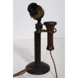 AN EARLY BAKELITE METAL AND BRASS TELEPHONE the cylindrical column raised on a circular spreading