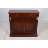 AN EMPIRE DESIGN MAHOGANY SIDE CABINET of rectangular outline the shaped top with frieze drawer and
