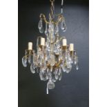 A CONTINENTAL GILT BRASS AND CUT GLASS SIX BRANCH CHANDELIER hung with pendent drops 80cm drop THE