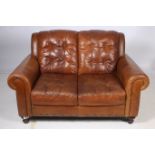 A RETRO HIDE UPHOLSTERED TWO SEATER SETTEE the panelled back and seat with scroll over arms on bun