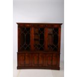 A GEORGIAN DESIGN MAHOGANY LIBRARY BOOKCASE of concave outline the dentil moulded cornice above