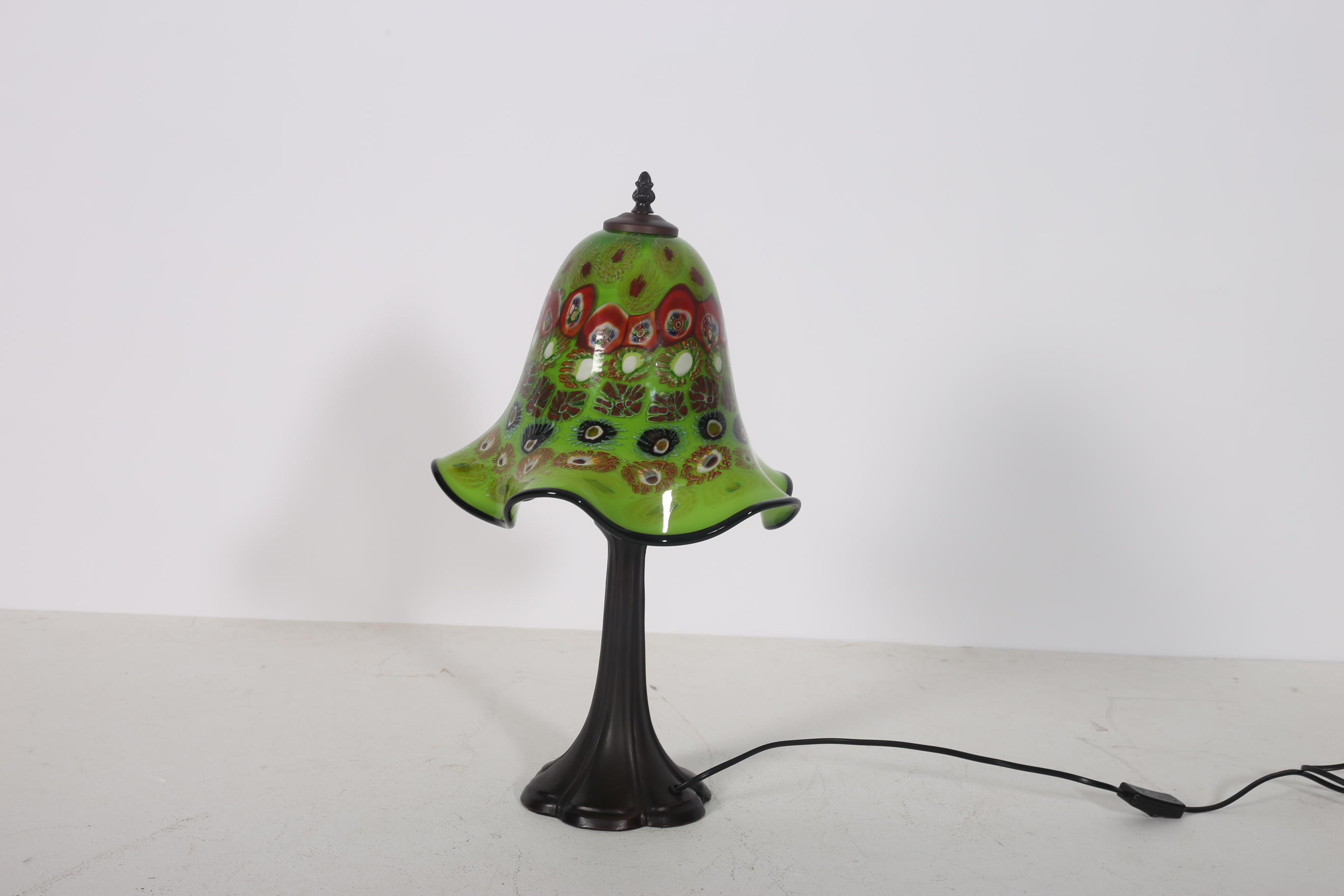 AN ART DECO DESIGN TABLE LAMP the multicoloured glazed shade above a tapering column with spreading