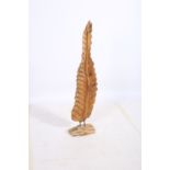 A CARVED WOOD SCULPTURE in the form of a leaf raised on a naturalistic base 120cm (h)