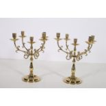 A PAIR OF BRASS FIVE BRANCH CANDELABRA with scroll arms and circular drip pans above a baluster