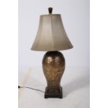 AN AFRICAN BRASS TABLE LAMP of baluster form etched with figures horses and foliage on square base