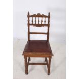 AN ARTS AND CRAFTS OAK SIDE CHAIR with baluster splats and hide upholstered seat on reeded turned