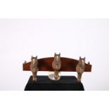 A MAHOGANY WALL MOUNTED THREE HOOK COAT HANGER with horse head hooks 24cm x 60cm