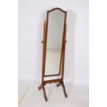 A MAHOGANY CHEVAL MIRROR the rectangular plate within a reeded frame raised on a moulded stand with