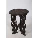 A BURMESE CARVED WOOD OCCASIONAL TABLE of circular outline the shaped top profusely carved overall