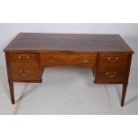 A 19TH CENTURY MAHOGANY DESK of rectangular outline the shaped top with five frieze drawers and