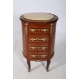 A CONTINENTAL MAHOGANY AND GILT BRASS MOUNTED CHEST of oval outline the shaped top with veined