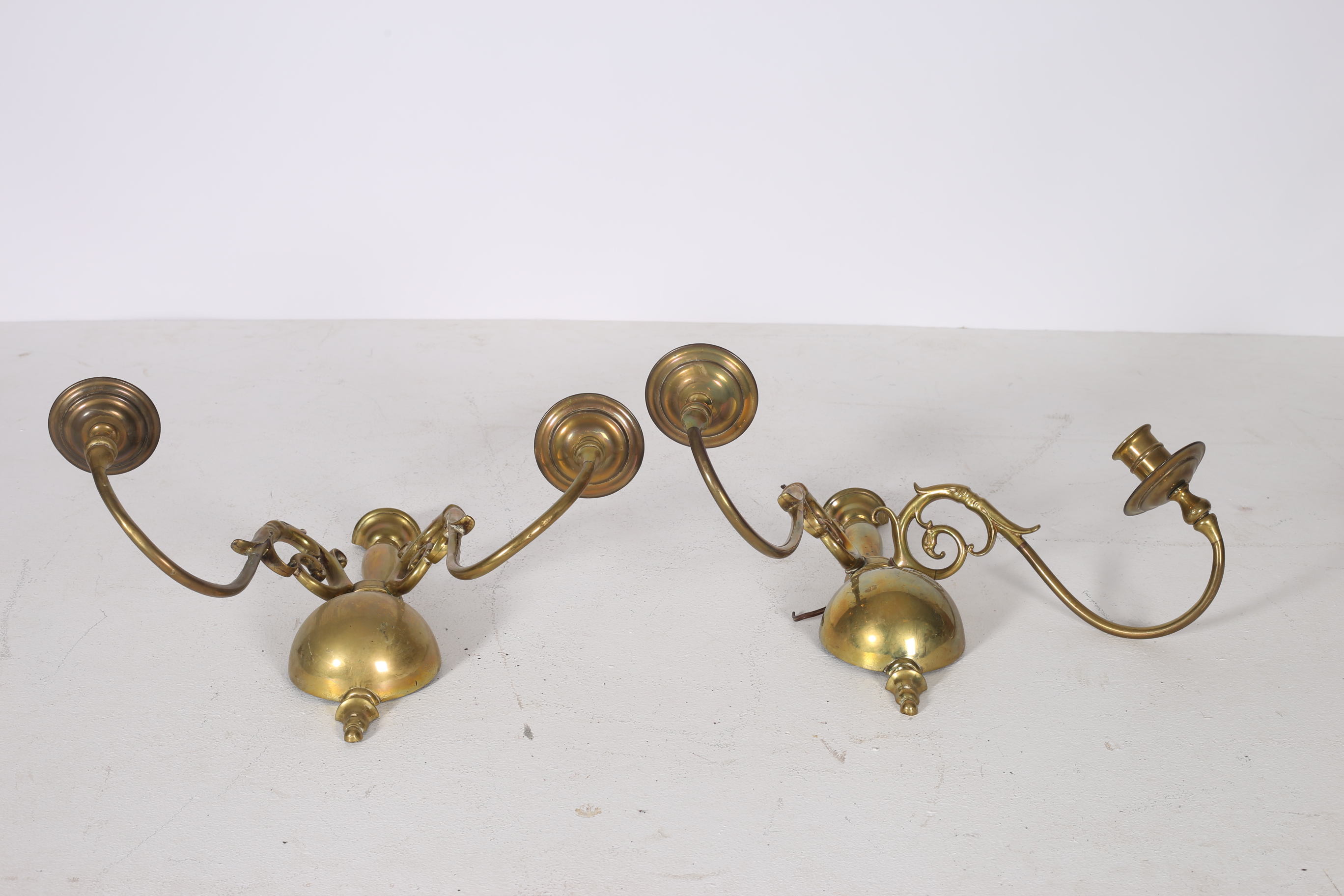 A PAIR OF BRASS TWO BRANCH WALL SCONCES each with a urn and bulbous back plate issuing two scroll