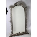 A CONTINENTAL SILVER FRAMED MIRROR the rectangular shaped plate within a pierced and carved