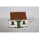 A FOOT WIPE in the form of an Irish cottage with thatched roof 22cm (h)
