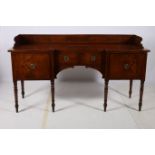 A GEORGIAN MAHOGANY SIDEBOARD of inverted breakfront outline the shaped top with moulded three