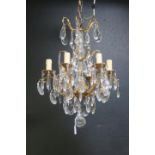 A CONTINENTAL GILT BRASS AND CUT GLASS SIX BRANCH CHANDELIER hung with pendent drops 80cm drop