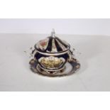 A CONTINENTAL PORCELAIN LIDDED TUREEN AND STAND the flow blue and white in gilt ground floral