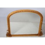 A VICTORIAN DESIGN GILT FRAME MIRROR the rectangular arched plate with a flowerhead and foliate