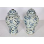 A PAIR OF ORIENTAL BLUE AND WHITE LIDDED JARS each of octagonal tapering form the white and blue