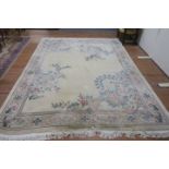 AN INDIAN WOOL RUG the beige ground with central panel containing floral sprays within a conforming