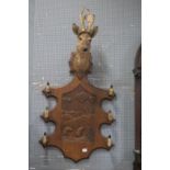 A 19TH CENTURY CARVED OAK WALL MOUNTED COAT RACK surmounted by a deer's head above a shaped carved