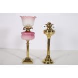 A 19TH CENTURY BRASS OIL LAMP the pink glazed reservoir with etched glass shade above a reeded