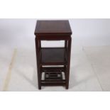 AN ORIENTAL HARDWOOD THREE TIER OCCASIONAL TABLE the square top inset with a simulated caned panel