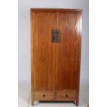 AN ORIENTAL HARDWOOD CUPBOARD of rectangular outline the cross banded panelled doors containing