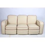 AN ART DECO DESIGN THREE PIECE SUITE comprising a three seater settee the rectangular arched back