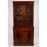 A GEORGIAN DESIGN MAHOGANY BOOKCASE the dentil moulded cornice above a pair of astragal glazed