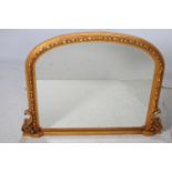 A VICTORIAN DESIGN GILT FRAME MIRROR the rectangular arched plate with a flowerhead and foliate