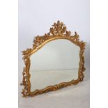 A CONTINENTAL GILT FRAMED MIRROR the shaped plate within a flower head and foliate frame 116cm x