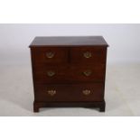 A GEORGIAN MAHOGANY CHEST of rectangular outline the shaped top above two short and two long