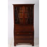 A GEORGIAN DESIGN MAHOGANY BUREAU BOOKCASE the outswept moulded cornice above a pair of astragal