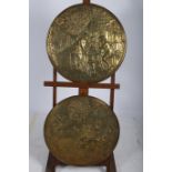 A PAIR OF BRASS EMBOSSED PLAQUES each of circular outline embossed figures seated outside an inn
